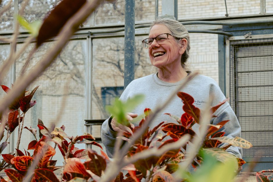 Landscape Service employee, Colleen Thomas, tends to flowers in the greenouse.