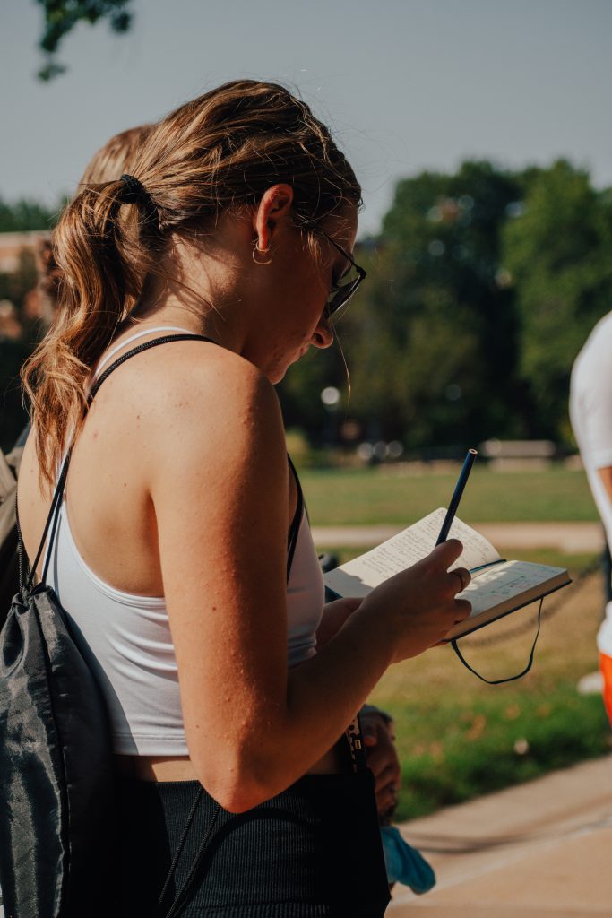Honor student takes notes during a tour of the Mizzou Botanic Garden